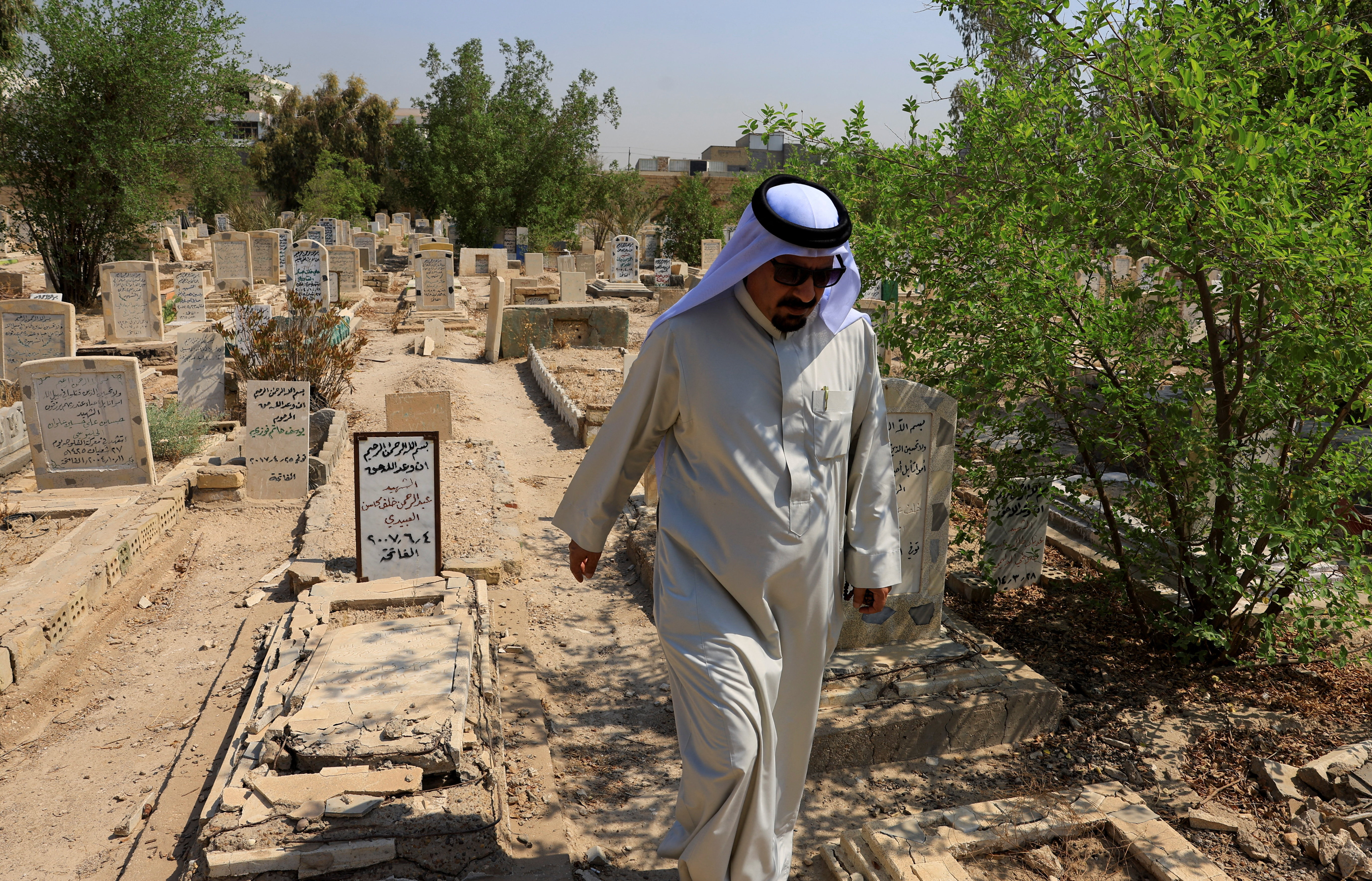 Sunni tribal sheikh Abdul Rahman al-Zobaie walks through the Martyrs' Cemetery in Falluja