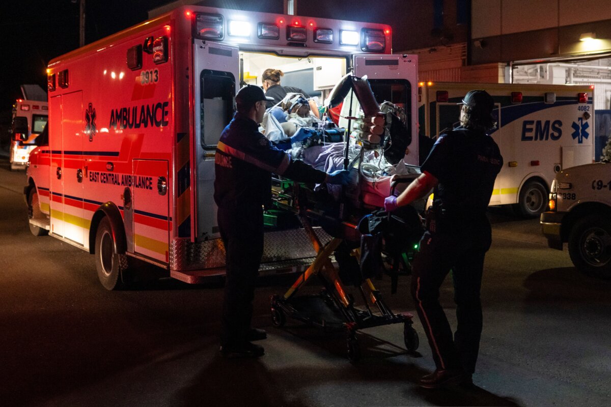 Paramedics load an injured person into an ambulance at the Wainwright Health Centre as injured military members are treated after a fire at Canadian Forces Base Wainwright, outside of Wainwright, Alberta, Oct. 17, 2026. (John Ulan/The Canadian Press via AP)