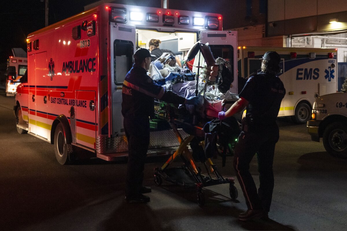 Paramedics load an injured person into an ambulance at the Wainwright Health Centre as injured military members are treated after a fire at CFB Wainwright, outside of Wainwright, Alta., on Oct. 17, 2026. (The Canadian Press/John Ulan)