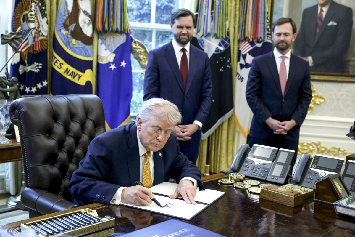 President Donald Trump signs an executive order as Vice President JD Vance (2nd L) and Federal Trade Commission Chairman Andrew Ferguson (R) look on during a White House signing ceremony in the Oval Office of the White House in Washington on March 16, 2026. (Alex Wong/Getty Images)