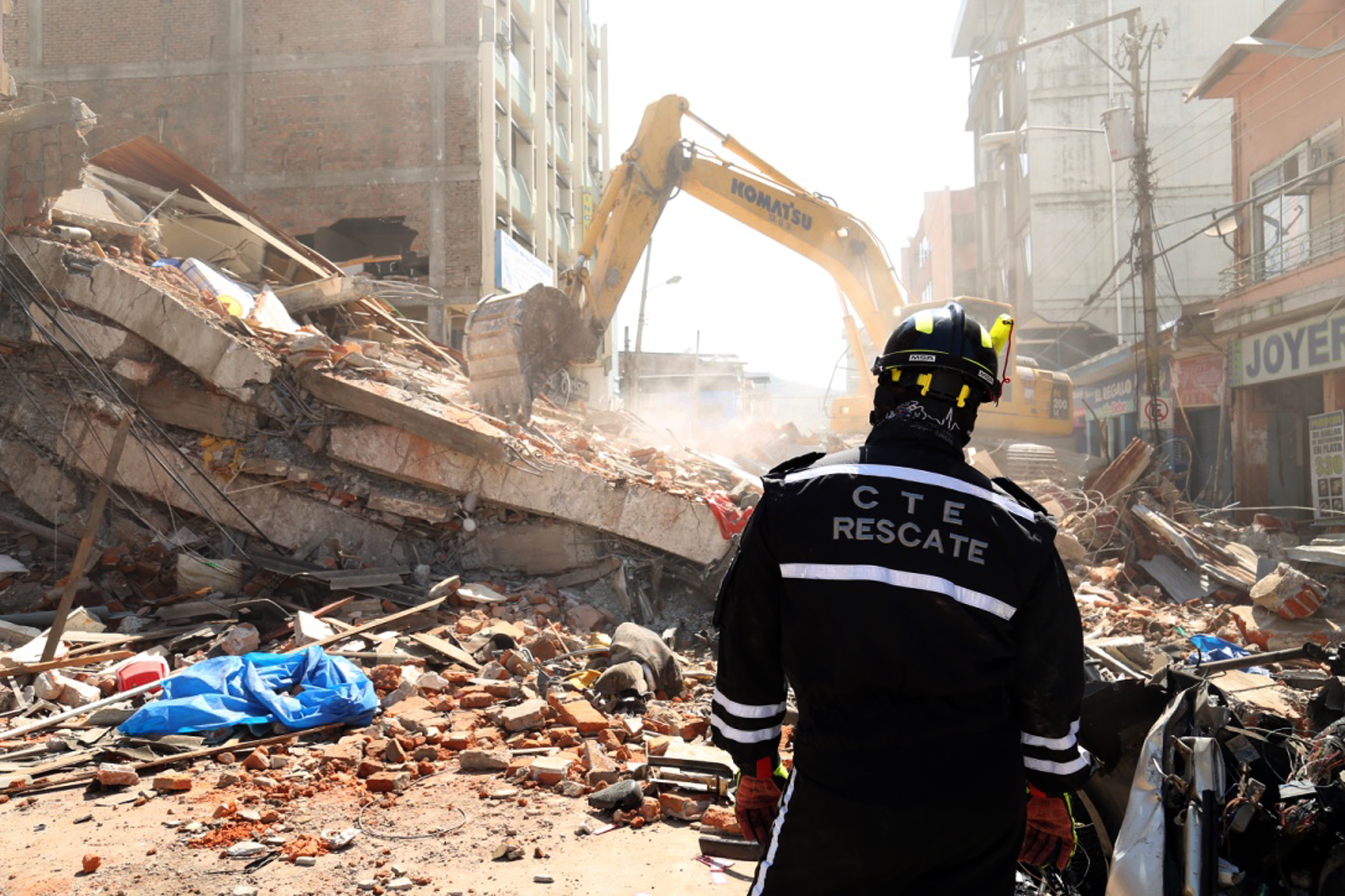 A rescue worker looks as heavy machinery removes the debris of a collapsed building in Portoviejo, Ecuador, Sunday April 17, 2016. A magnitude-7.8 quake, the strongest since 1979, hit Ecuador flattening buildings, buckling highways along its Pacific coast and killing hundreds. (AP Photo/Carlos Sacoto)
