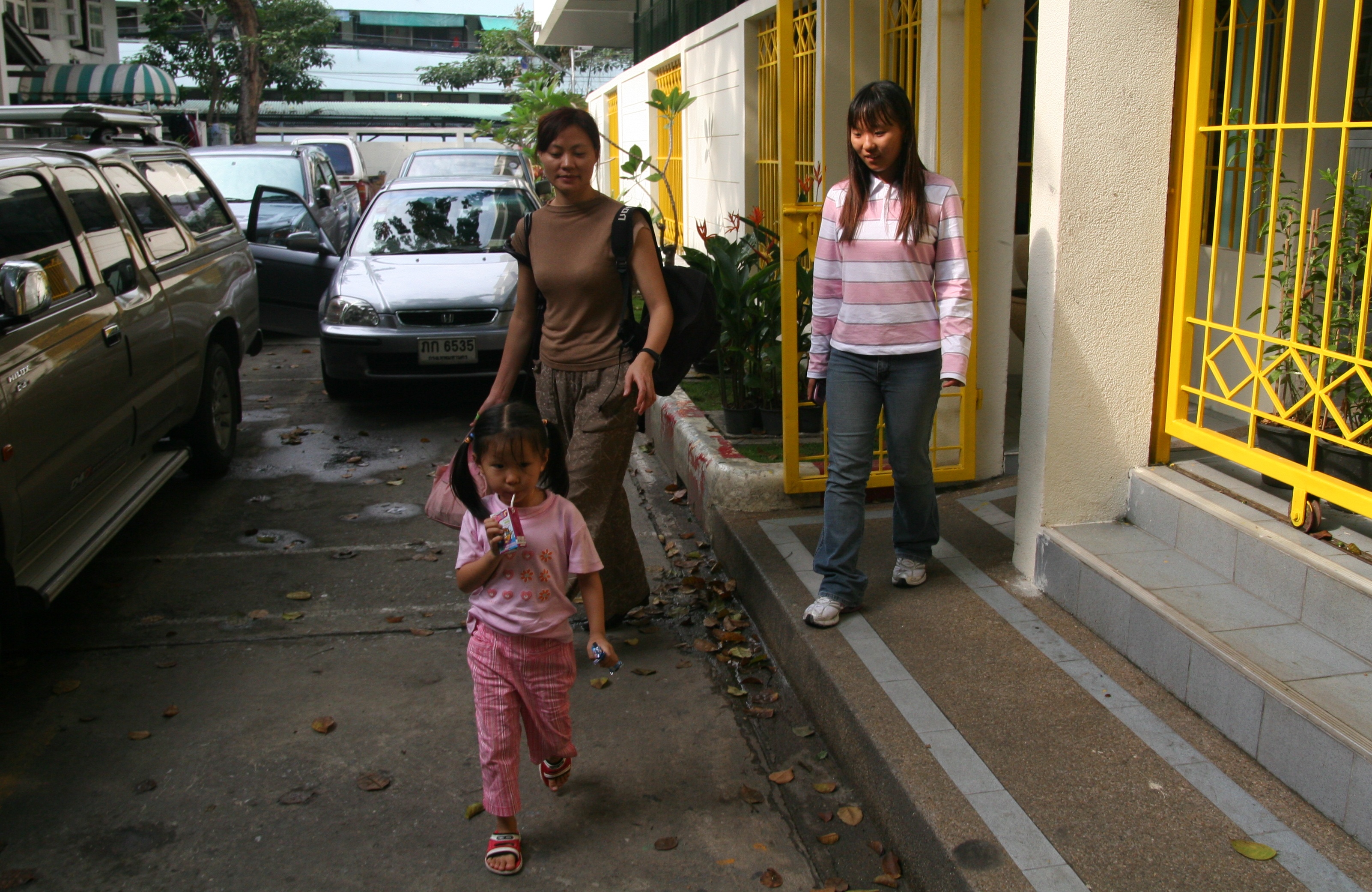 Four-year-old Huang Ying leaves the Immigration Detention Center (IDC) in Bangkok, with a family friend and 14-year-old Wang Anqi, whose parents are still incarcerated and had their visas to Thailand cancelled. They are appealing the decision. (The Epoch Times)
