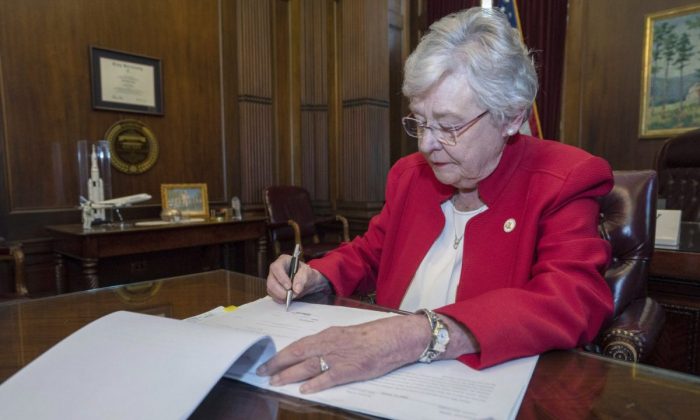 Alabama Gov. Kay Ivey signs into law the Alabama Human Life Protection Act, after both houses of the legislature passed the bill, in Montgomery, Ala., in a file photograph. (Office of the Governor State of Alabama/Handout via Reuters)