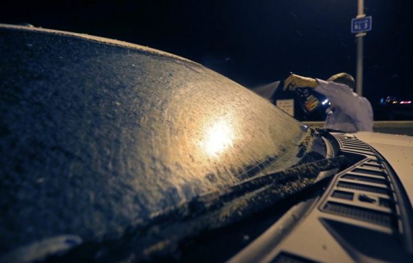 Motorist Blake Campo uses liquid wax, the only liquid he had, to clean his bug covered windshield,