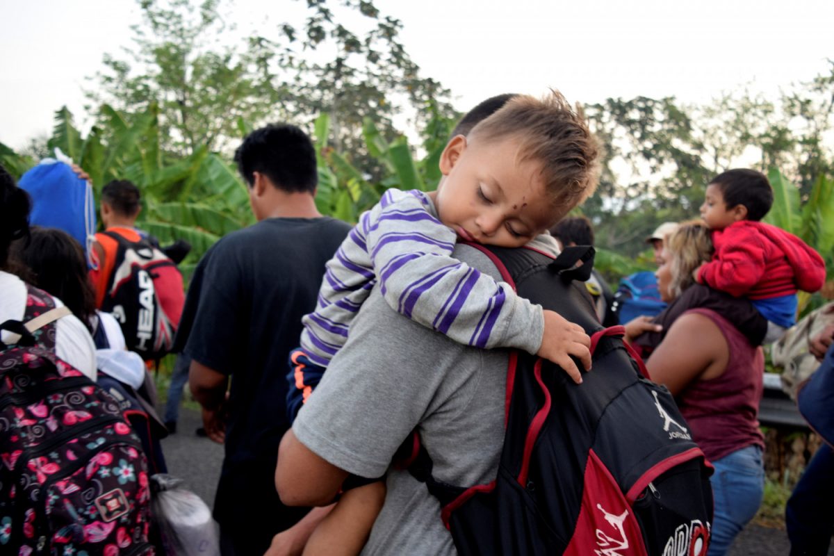 Migrants from Central America and Cuba walk on a highway