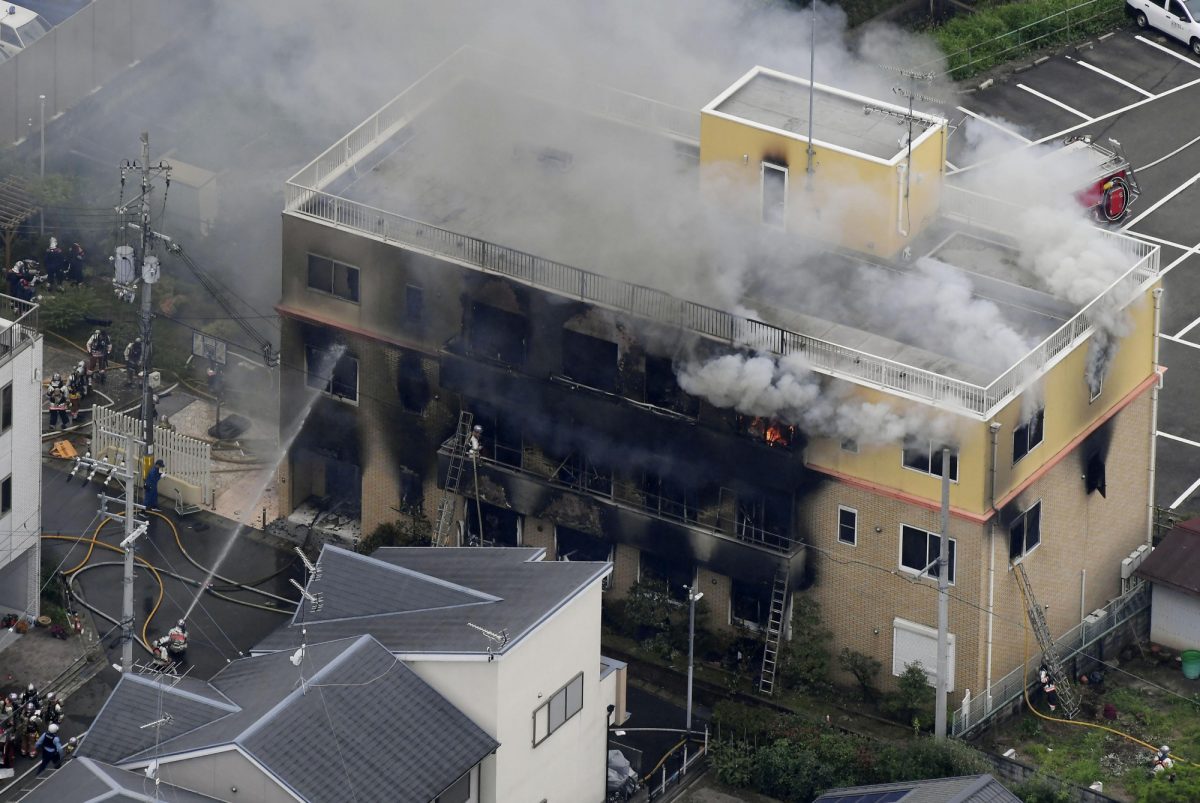 Smoke billows from a three-story building