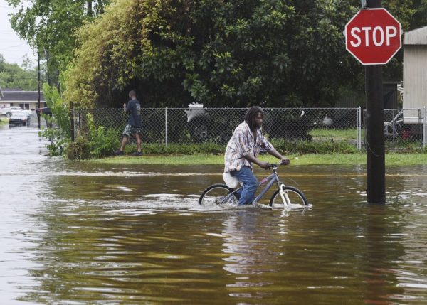 A man tries to bike through the flooding