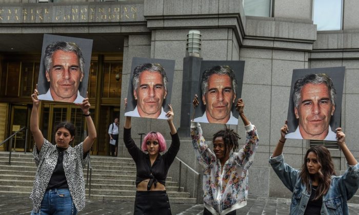 A protest group called "Hot Mess" hold up signs of Jeffrey Epstein in front of the Federal courthouse in New York City on July 8, 2019. (Stephanie Keith/Getty Images)