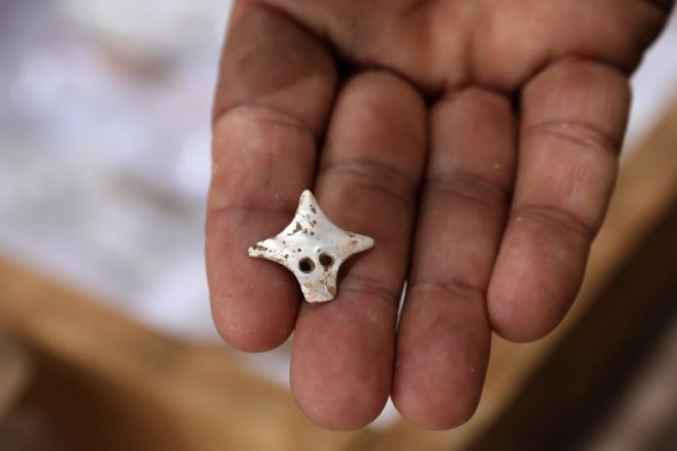 A mother of pearl pendant discovered on a skeleton at the site
