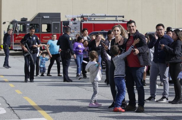 Shoppers hug after being escorted from the Tanforan Mall