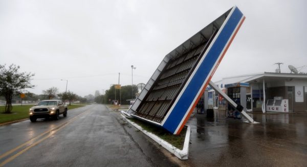 A vehicle passes a toppled gas pump canopy in Berwick
