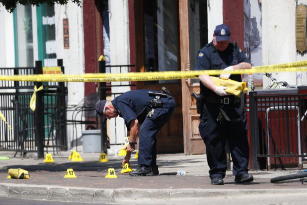 Authorities retrieve evidence markers at the scene of a mass shooting in Ohio