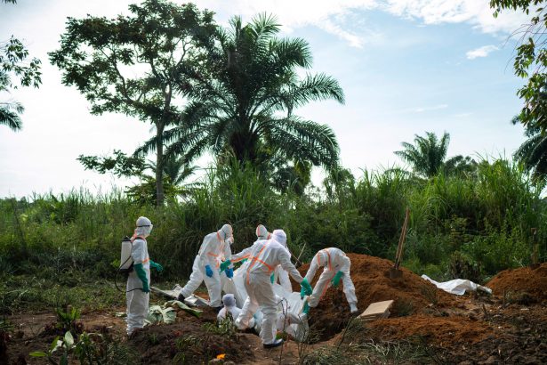 Workers bury the remains of Mussa Kathembo