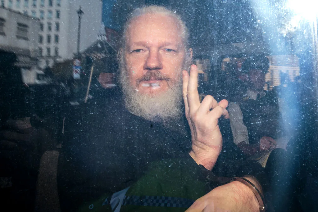 Julian Assange gestures to the media from a police vehicle on his arrival at Westminster Magistrates' Court in London on April 11, 2019. (Jack Taylor/Getty Images)