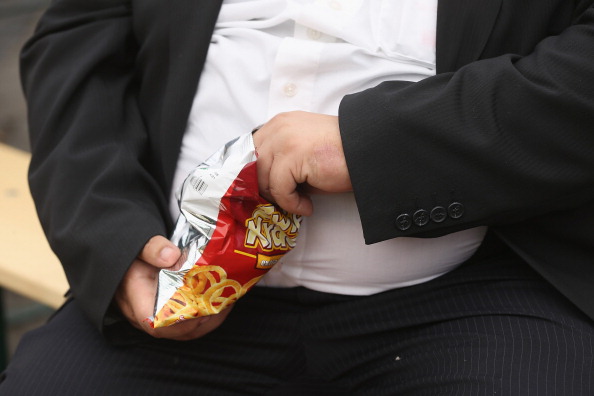 A man with a large belly eats junk food on May 23 in Leipzig, Germany. (Photo by Sean Gallup/Getty Images)