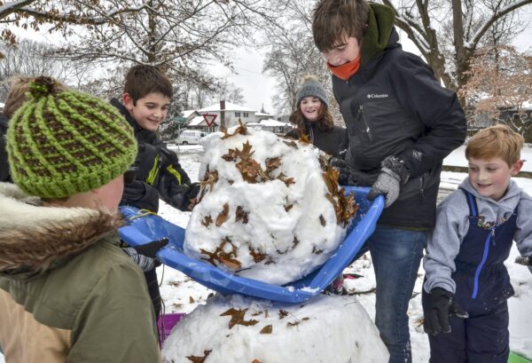kids lift a snowball